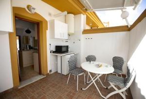 a small kitchen with a white table and chairs at Bluemoon 2 in Mazarrón +10 photos
