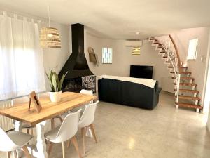 a living room with a dining table and a spiral staircase at Torre a Sant Martí d'Empúries in L'Escala