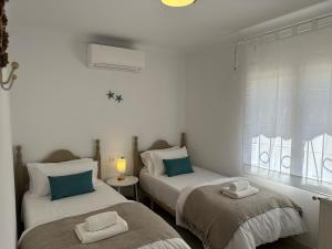 two twin beds in a room with a window at Torre a Sant Martí d'Empúries in L'Escala