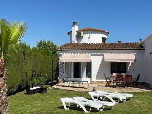 a group of white chairs and a table and a house at Torre a Sant Martí d'Empúries in L'Escala
