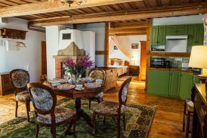 a kitchen and dining room with a table and chairs at Marcienas Muiza & SPA in Mārciena