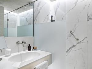 a white bathroom with a sink and a shower at Semeli Estate Suites in Koútsion +27 photos