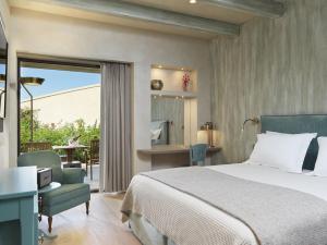 a bedroom with a bed and a desk and a chair at Semeli Estate Suites in Koútsion