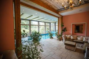 a living room with a couch and a large window at Marcienas Muiza & SPA in Mārciena