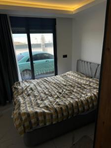 a bedroom with a bed and a car outside a window at Mertcan Doruk in Side +5 photos