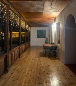 an empty room with a wooden floor and a table at Guesthouse Lantia in Mestia +24 photos