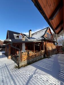 a building with snow on the ground in front of it at Goralska Chalupa in Vígľaš