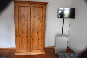 a wooden cabinet with a television on top of it at Toscana1 in Freimersheim