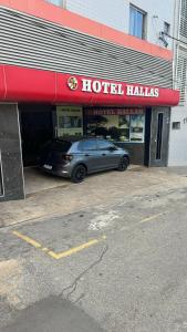 a car parked in front of a hotel haljas at Hotel Hallas in Betim