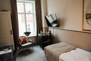 una camera da letto con un letto e una TV a parete di Hotel Royal a Arhus