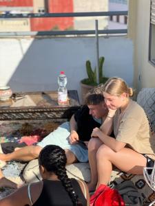 a group of people sitting on a bed at Adrenalin Surf House in Tamraght Ouzdar