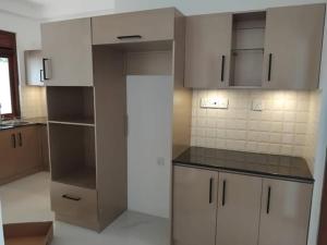 a kitchen with white cabinets and black counter tops at Hotel & Restaurant Chingari Pinnawala in Rambukkana