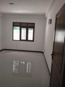 an empty room with a window and a door at Hotel & Restaurant Chingari Pinnawala in Rambukkana