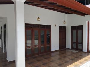 a row of wooden doors on a white building at Hotel & Restaurant Chingari Pinnawala in Rambukkana