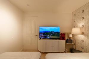 a bedroom with a flat screen tv on a white cabinet at 포레스트101 in Seoul