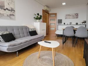 a living room with a couch and a table at Apartamento Medrano PISCINA AIRE ACONDICIONADO terraza y 5 minutos del centro en coche ideal para mascotas in Logroño