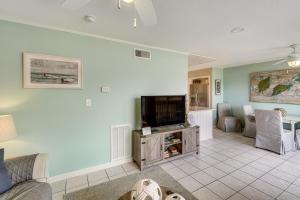 a living room with a tv and a couch at Golf Course Views! Couple's Retreat in Diamondhead in Diamondhead