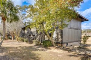 a building with a staircase next to a tree at Golf Course Views! Couple's Retreat in Diamondhead in Diamondhead