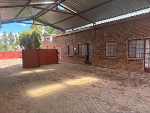 a brick building with awning and a brick courtyard at Philly-Wen Guesthouse in Schweizer-Reineke
