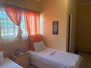 a bedroom with two twin beds and a window at Philly-Wen Guesthouse in Schweizer-Reineke