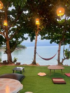 a hammock in a park with a view of the water at Beach Yard Hostel in Ban Nua