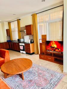 a living room with a table and a fireplace at JJ Comfort Homes in Arusha