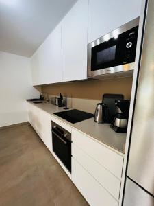 a kitchen with white cabinets and a stove top oven at La Tejita "Vida" by BE HAPPY in La Tejita
