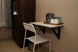 a table with a chair and a shelf with bottles on it at Rajbari Palace in Deoghar