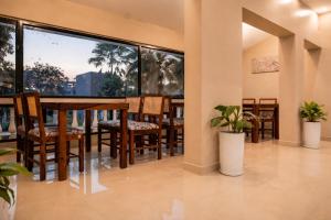 a dining room with a table and chairs and large windows at Rajbari Palace in Deoghar +48 photos