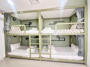 a room with three bunk beds in a room at Beach Yard Hostel in Ban Nua
