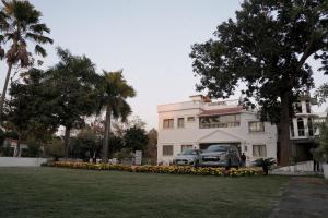 a white building with cars parked in front of it at Rajbari Palace in Deoghar
