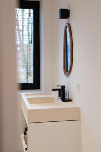 a bathroom with a sink and a mirror at Stories Lodewijk en Margaretha in Bruges +33 photos