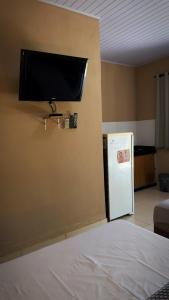 a room with a refrigerator and a tv on the wall at Pousada Sítio Rupestre Peruaçu in Januária