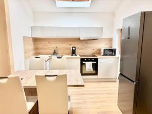 a kitchen with white cabinets and a table and chairs at Thyez rue des Acacias in Thyez +25 photos