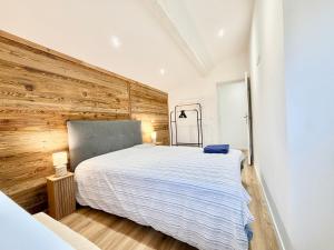 a bedroom with a large bed and a wooden wall at Thyez rue des Acacias in Thyez
