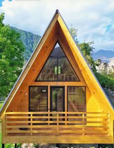 a frame cabin with a triangular roof and windows at Cottage Dachi in Mestia in Mestia