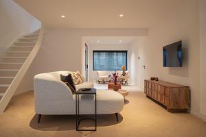 a living room with a couch and a staircase at Stories Lodewijk en Margaretha in Bruges