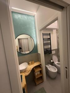 a bathroom with a sink and a toilet and a mirror at Stay & Solution Apartment in Trieste +16 photos