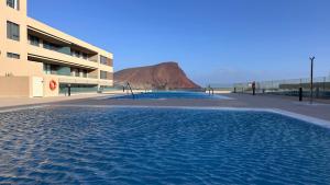 a large pool of water in front of a building at La Tejita "Vida" by BE HAPPY in La Tejita