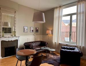 a living room with leather furniture and a fireplace at Hotel Saint Georges in Mons