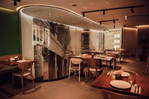 a restaurant with tables and chairs and a large wall at Hotel Indigo Madrid - Gran Vía by IHG in Madrid
