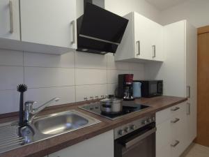 a kitchen with a sink and a stove top oven at Ferienwohnung Annenblick in Sankt Wendel +4 photos