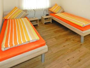 two beds in a room with wooden floors at Ferienwohnung Landblick, Rastede in Rastede