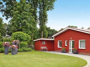 a red house with a lawn in front of it at Ferienwohnung Landblick, Rastede in Rastede