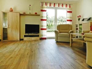 a living room with a flat screen tv and a couch at Ferienwohnung Landblick, Rastede in Rastede +2 photos