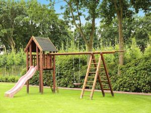 a wooden playground with a slide and a ladder at Ferienwohnung Landblick, Rastede in Rastede