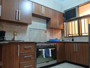 a kitchen with wooden cabinets and a stove top oven at Dafrican BnB in Kigali