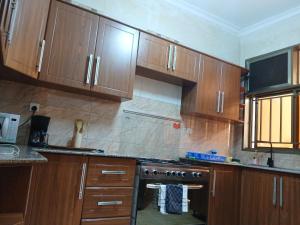a kitchen with wooden cabinets and a stove at Dafrican BnB in Kigali +9 photos