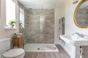 a bathroom with a shower and a toilet and a sink at Greenhead Cottage in Kelso +23 photos