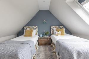 two beds in a attic room with blue walls at Greenhead Cottage in Kelso